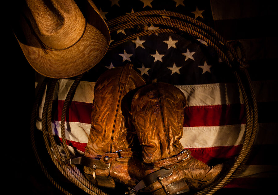 American flag with cowboy boots, rope, and cowboy hat
